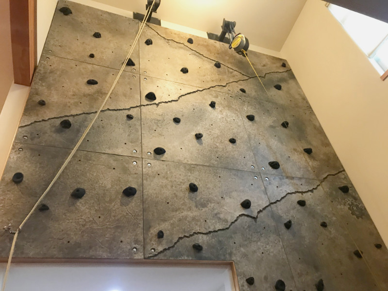 Looking up at a multi-story climbing wall installed in a foyer