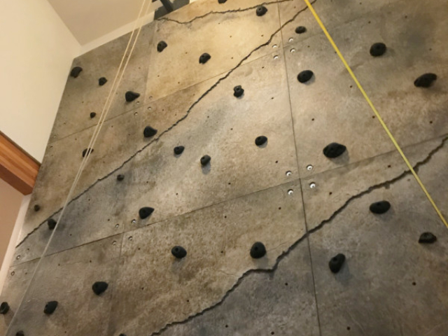 Looking up at a climbing wall installed within the foyer of a Seattle home.