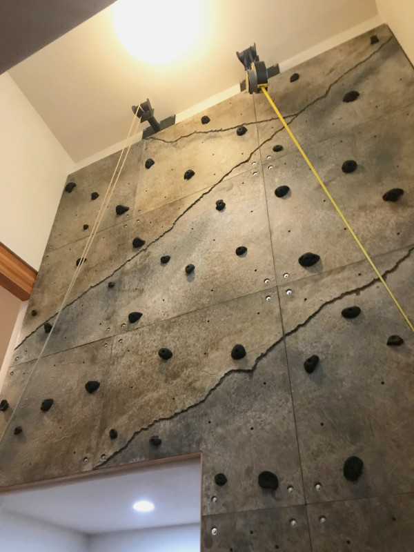 Looking up at a climbing wall installed within the foyer of a Seattle home.