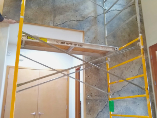 Home climbing wall installation, with scaffolding in foyer.